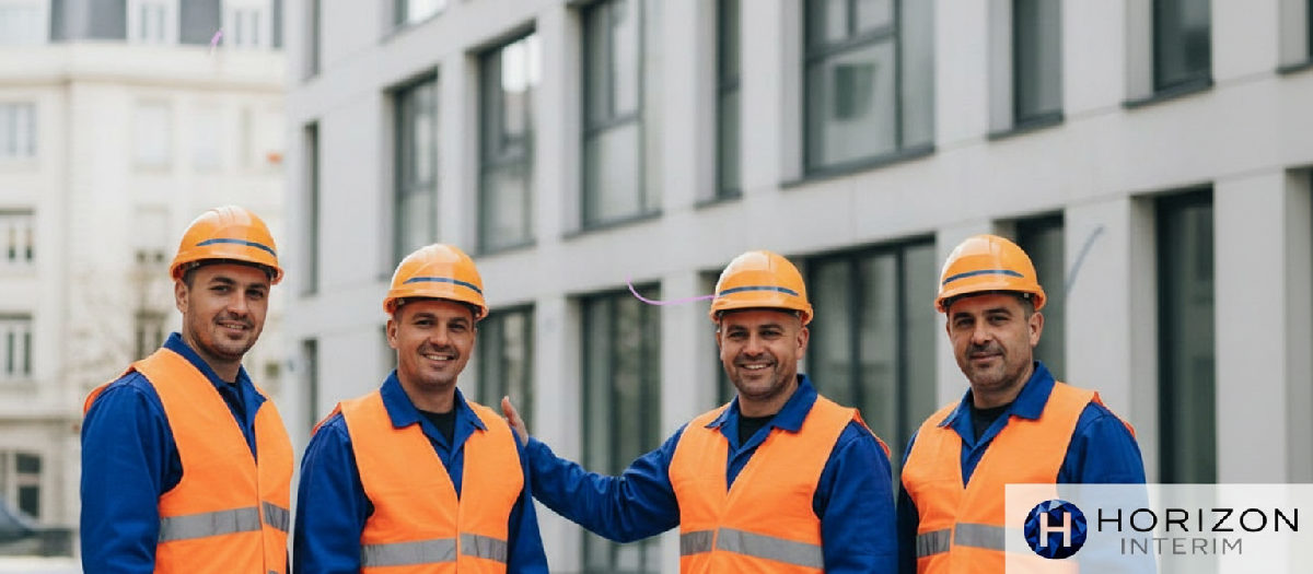 Ouvriers roumains souriants devant un chantier de construction français réussi.